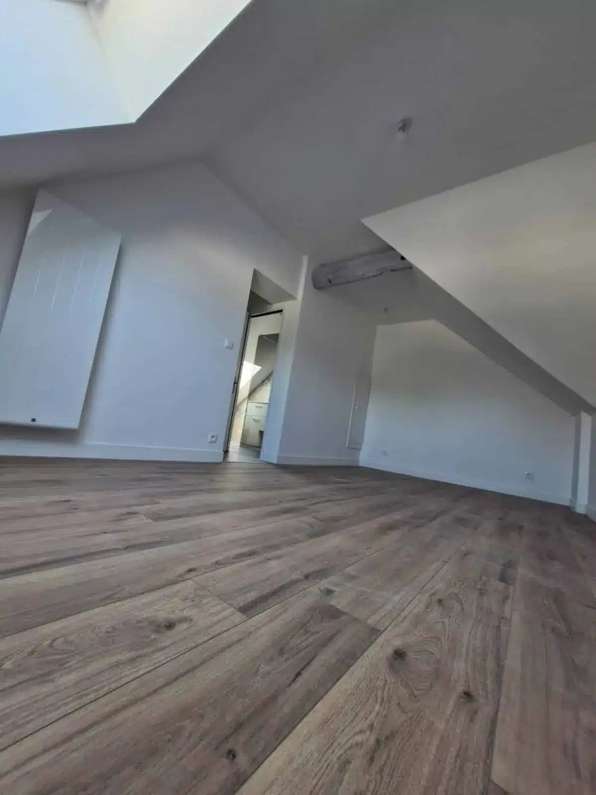 Pièce sous combles repeinte en blanc avec parquet contrecollé