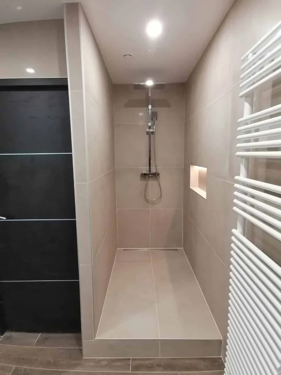 Douche à l'italienne avec paroi vitrée, colonne de douche, niche et radiateur sèche-serviettes