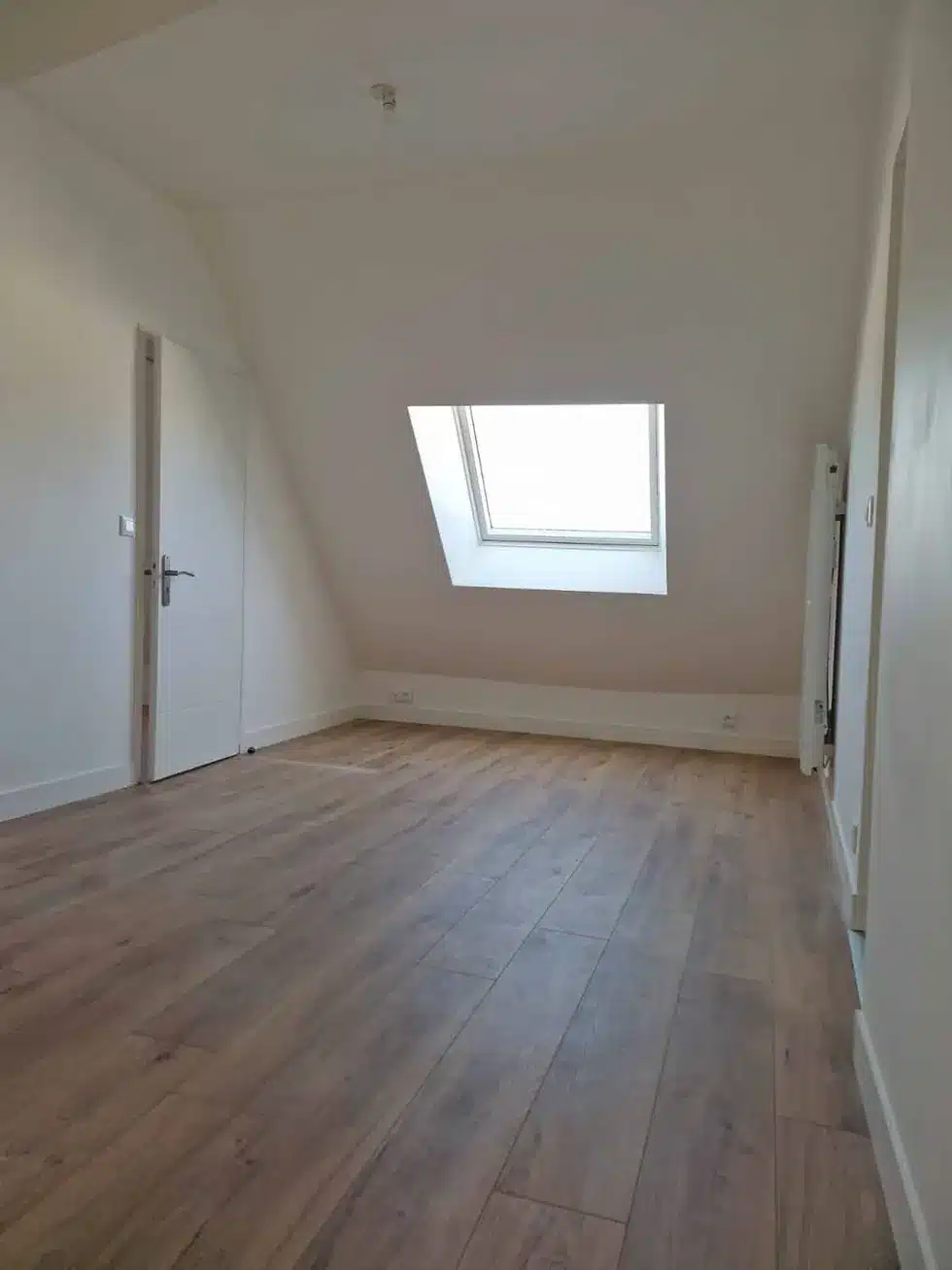 Chambre sous combles avec fenêtre de toit et parquet contrecollé