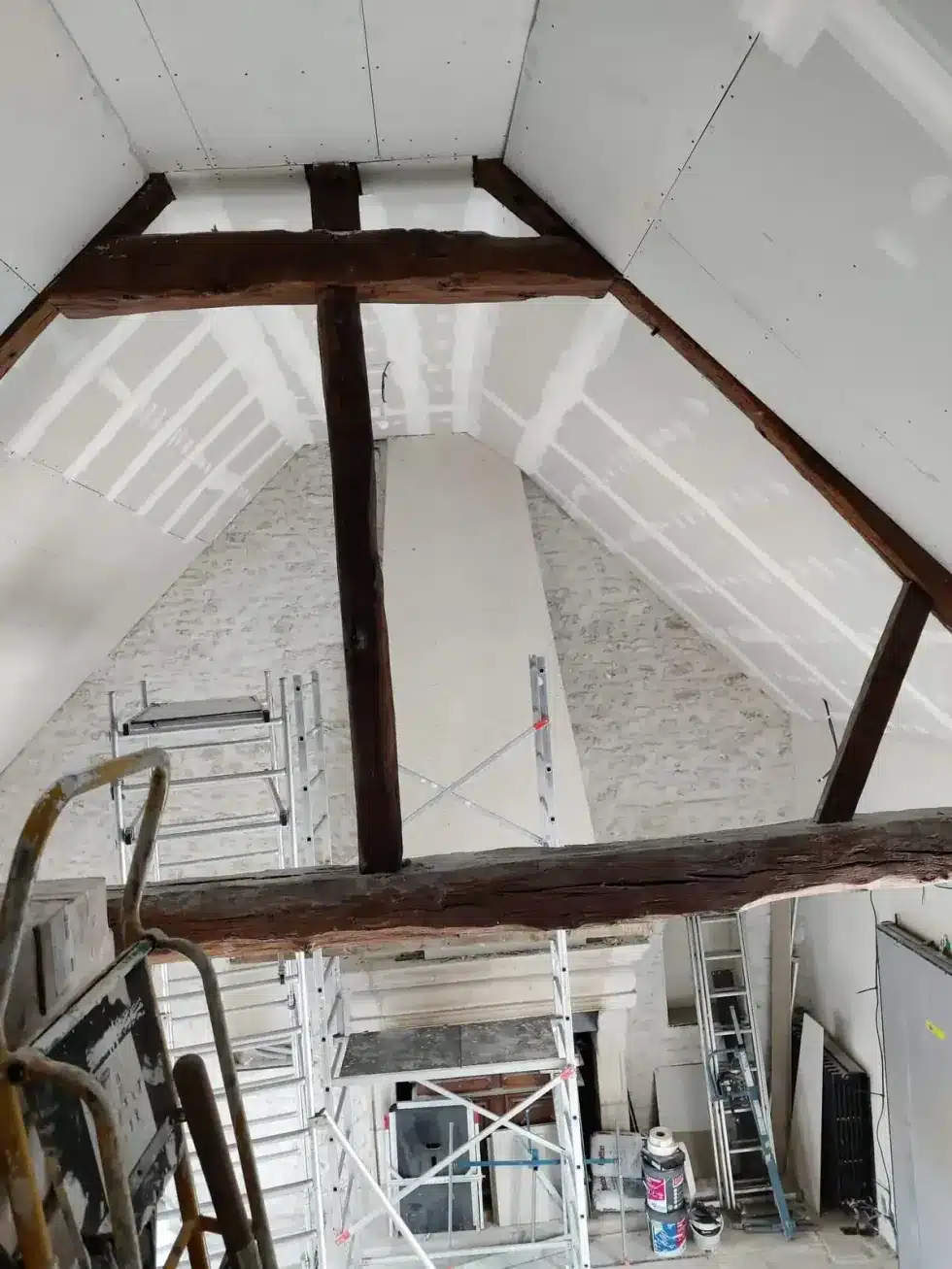entreprise de rénovation intérieure Yvelines Pièce en rénovation avec charpente bois apparente et échafaudage